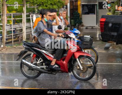 SAMUT PRAKAN, THAILAND, SEP 21 2022, Menschen fahren Motorräder auf der Straße im Regen Stockfoto
