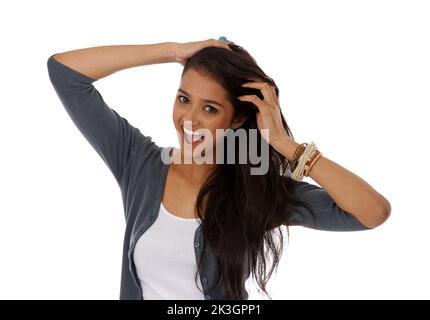 Glücklich mit ihrem Haarpflegeprogramm. Eine junge ethnische Frau lächelt, während sie ihre Finger durch ihre Haare läuft. Stockfoto