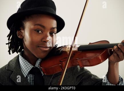 Y. Ein junger afroamerikanischer Junge, der mit einer Geige im Studio posiert. Stockfoto