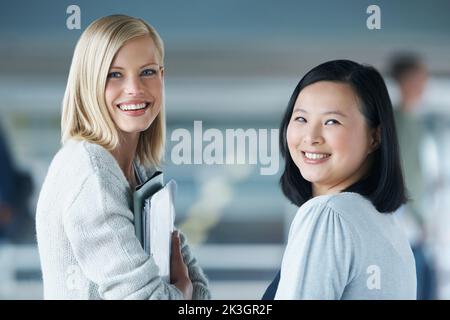 In die Klasse. Zwei junge Studenten lächeln, während sie die Kamera betrachten. Stockfoto