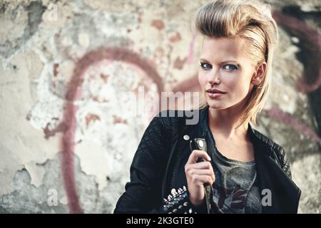 Rockin diesem Stil. Beschnittenes Porträt einer kantigen jungen Frau in einer urbanen Umgebung. Stockfoto