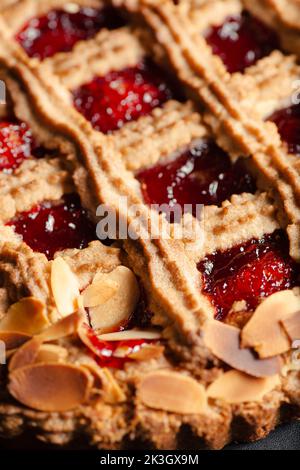 Die Linzer Torte ist ein traditionelles österreichisches Gebäck, eine Form von Shortbread, gekrönt mit Fruchtkonserven und geschnittenen Nüssen mit einem Gitterdesign auf der Oberseite. Stockfoto