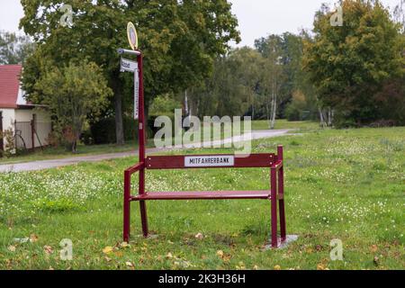 Eine Bank mit einem Schild mit der deutschen Aufschrift rideshare Bank und Richtungsschilder mit den deutschen Aufschriften opencast Bergbausee und Altstadt Stockfoto