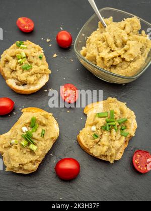 Vorspeise rumänischer Auberginen-Salat mit Zwiebeln und Tomaten auf Brot verteilt Stockfoto