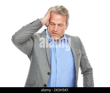 Ich brauche ein Aspirin. Studioaufnahme eines reifen Geschäftsmanns, der vor Schmerzen sucht. Stockfoto