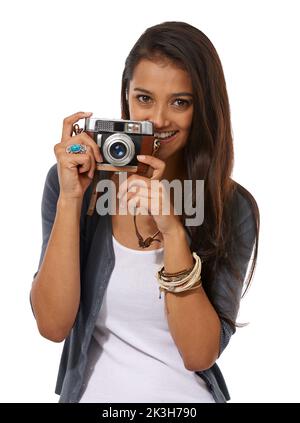 Sagen Sie Käse. Beschnittenes Porträt eines jungen Fotografen, der eine Kamera in der Hand hält, während er vor einem weißen Hintergrund steht. Stockfoto