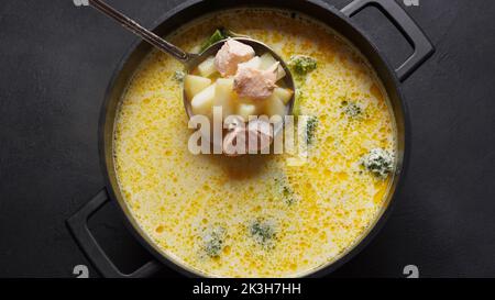 Cremige Fischsuppe mit Lachs, Kartoffeln, Zwiebeln, Karotten, Dill und Brokkoli in einem Topf. Kalakeitto - traditionelles Gericht der finnischen Küche. Gesund Stockfoto