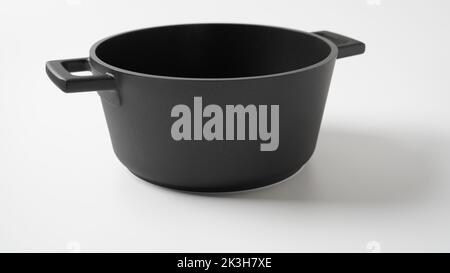 Schwarzer Topf auf weißem Hintergrund. Utensilien zum Kochen Stockfoto