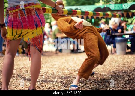 Ich werde es nicht schaffen...ein Mann in einem Tierkostüm, der den Limbo macht. Stockfoto