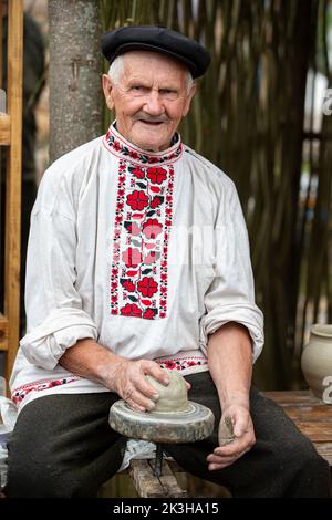 Ein Urlaub der ethnischen Kulturen. Ein alter slawischer Mann in einem weißrussischen Hemd mit Leinenstickerei modelliert Stockfoto