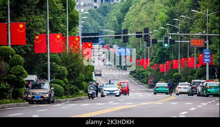 CHONGQING, CHINA - 26. SEPTEMBER 2022 - Nationalflaggen fliegen auf einer Straße, um den Nationalfeiertag in Chongqing, China, am 26. September 2022 zu feiern. Stockfoto