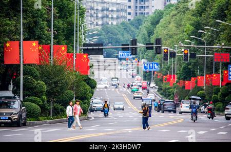 CHONGQING, CHINA - 26. SEPTEMBER 2022 - Nationalflaggen fliegen auf einer Straße, um den Nationalfeiertag in Chongqing, China, am 26. September 2022 zu feiern. Stockfoto