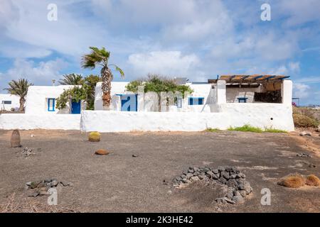 Typisches weißes Haus auf der Insel La Graciosa, mit Wüstenvegetation, Lanzarote, Kanarische Inseln, Spanien. Stockfoto