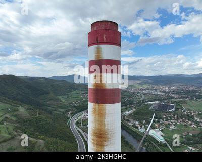 Luftdrohne von Kohlekraftwerk mit zwei hohen Kühltürmen am blauen Fluss. Rauch aus Kaminen und Dampf aus der Stromerzeugung Stockfoto