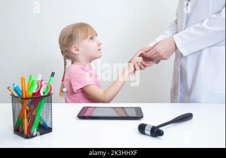 Ein Arzt des Neurologen überprüft den pathologischen Reflex eines hoffman bei einem Mädchen auf das Vorhandensein von Neuropathologien. Nervensystem, Neurologie Stockfoto