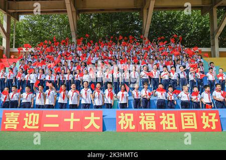 QINGZHOU, CHINA - 27. SEPTEMBER 2022 - Grundschüler schwenken Nationalflaggen und singen „I Love You China“ in Qingzhou, Provinz Shandong, China, Stockfoto