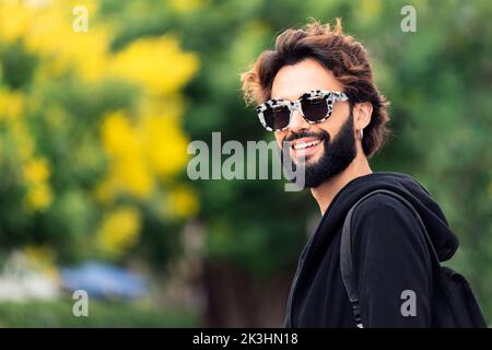 Mann mit modischer Sonnenbrille lächelt glücklich Stockfoto