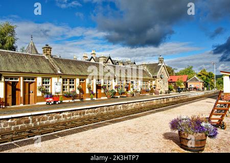 STRATHSPEY DAMPFEISENBAHN AVIEMORE SCHOTTLAND BOOT VON GARTEN BAHNSTEIG MIT BLUMEN IM SPÄTSOMMER Stockfoto