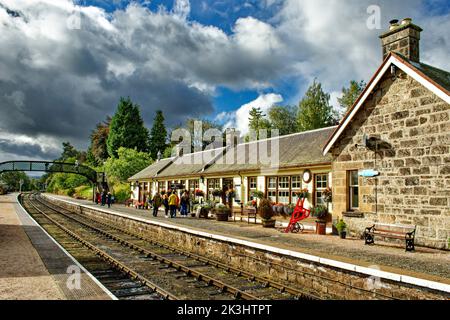 STRATHSPEY DAMPFEISENBAHN AVIEMORE SCHOTTLAND BOOT VON GARTEN BAHNSTEIG MIT PASSAGIEREN IM SPÄTSOMMER Stockfoto