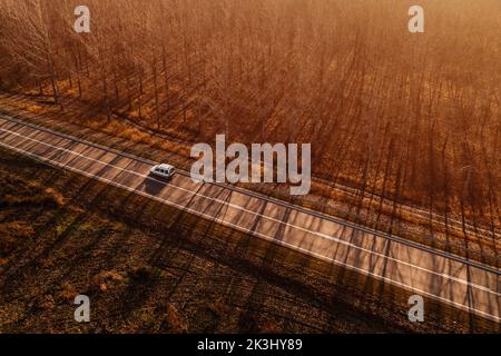 Luftaufnahme des Mehrzweck- (mpv) oder Freizeitfahrzeugs (lav) mpv auf der Straße durch die herbstliche Landschaft, Drohnenfotografie Stockfoto
