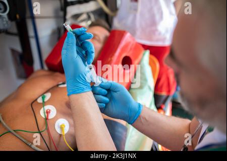 Ambulanzarzt bereitet sich darauf vor, einem Patienten eine Injektion zu verabreichen Stockfoto