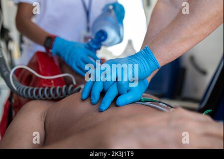 Paramedizinisches Personal, das die Herzmassage und Oxygenierung durchführt Stockfoto