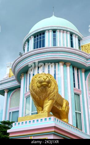 Eine vertikale Aufnahme eines goldenen Löwen vor einem Gebäude im Königlichen Palast in Bangkok, Thailand Stockfoto