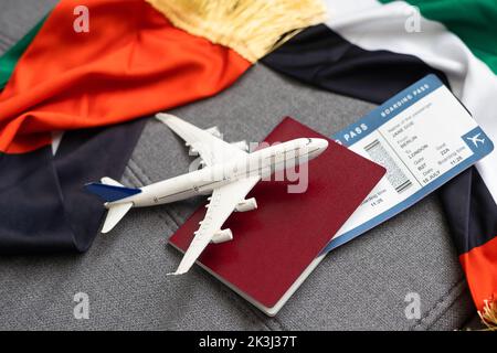 Nationale VAE, US-Flaggen, Spielzeugflugzeug und Pässe auf grauem Hintergrund Stockfoto