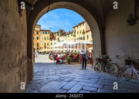 LUCCA, ITALIEN - 16. SEPTEMBER 2018: Dies ist eine der gewölbten Passagen zum Amphitheater Platz. Stockfoto