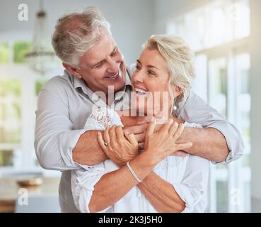 Seniorenpaar, glücklich und umarmt für Liebe, Unterstützung und Fürsorge in der Beziehung zu Hause Umarmung, Bindung oder Lächeln. Romantik, verheiratet oder Rentner alter Mann Stockfoto