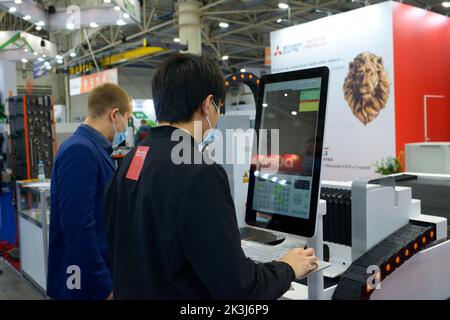 Arbeiter Programmierung CNC-Plasma-Schneidemaschine, um Metall zu schneiden. Branchenmesse. 17. November 2021. Kiew, Ukraine Stockfoto