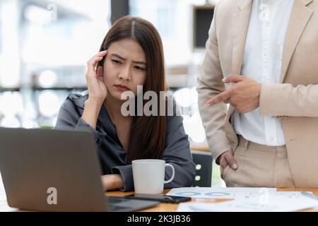 Eine betonte asiatische Geschäftsfrau analysiert die Finanzcharts. Account- und Audit-Konzept Stockfoto