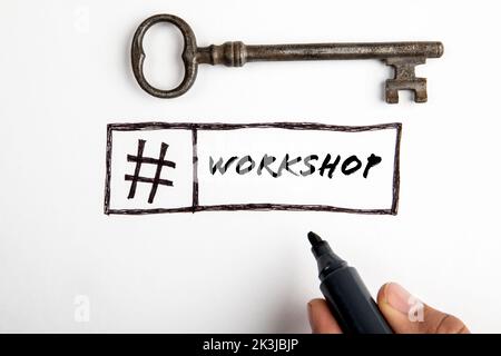 Workshop-Hashtag. Text und alter Türschlüssel auf weißem Hintergrund. Stockfoto