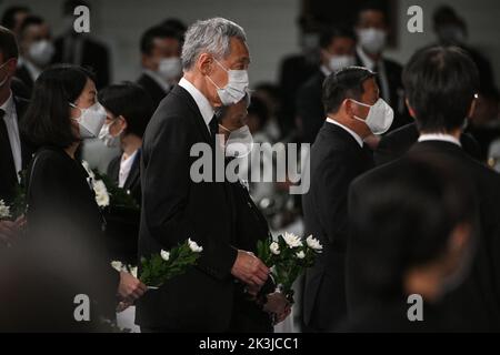 Tokio, Japan. 27. September 2022. Singapurs Premierminister Lee Hsien Loong (C) und seine Frau Ho Ching (hinten) bereiten sich darauf vor, während der staatlichen Beerdigung des ehemaligen japanischen Premierministers Shinzo Abe am 27. September 2022 im Nippon Budokan in Tokio Blumen auf den Altar zu legen. (Bild: © POOL via ZUMA Press Wire) Stockfoto