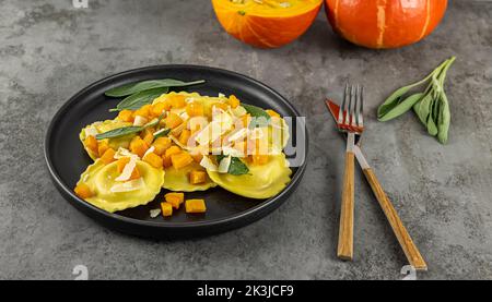 Saisonales Herbstrezept. Kürbisravioli mit Salbei, Parmesan und Olivenöl. Stockfoto