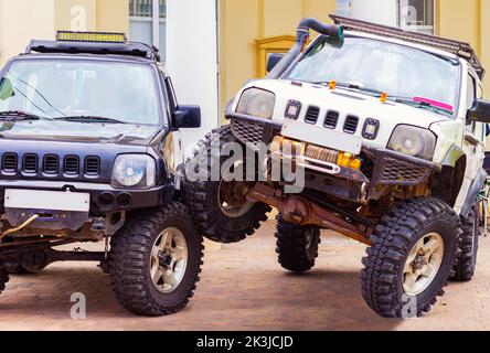 Suzuki Jimny Mini-SUV-Auto, Tomsk Russland 10. September 2022.ein Upgrade für bessere Cross-Country-Fähigkeit von Craftsmen.SUV fuhr auf das Rad eines anderen SUV Stockfoto