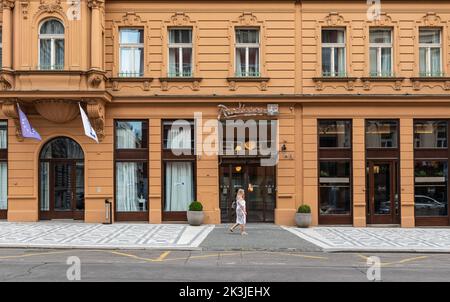 Prag - Tschechische Republik - 08 01 2020 Frau, die vor der Fassade des Radisson Blu Hotels in der Altstadt läuft Stockfoto