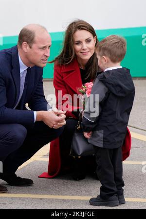 DER Prinz und die Prinzessin von Wales erhalten von dem vierjährigen Theo Crompton eine schicke Blumenpracht, als sie zur RNLI Holyhead Lifeboat Station in Holyhead, Wales, kommen, wo sie Crew treffen, Freiwillige und einige von denen, die von ihrer lokalen Einheit unterstützt wurden. Holyhead ist eine der drei ältesten Rettungsbootstationen an der walisischen Küste und hat eine bemerkenswerte Geschichte der Tapferkeit, da sie 70 Auszeichnungen für die Galanterie erhalten hat. Bilddatum: Dienstag, 27. September 2022. Stockfoto