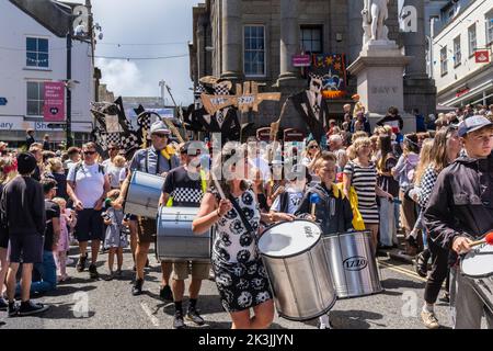 Bei den Feierlichkeiten zum Mazey Day im Rahmen des Golowan Festivals in Penzance in Cornwall, Großbritannien, trommelten Menschen in der Parade. Stockfoto