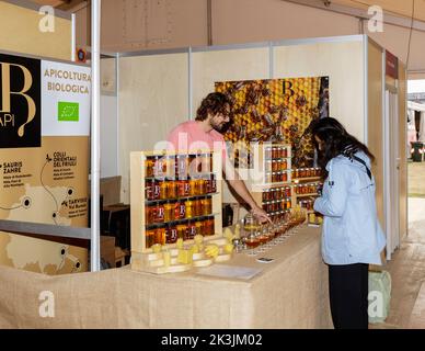 Turin, Italien - 23. September 2022: Während der Messe 'Terra Madre - Salone del Gusto' (kostenlose Veranstaltung), Honigverkäufer mit einem Kunden Stockfoto