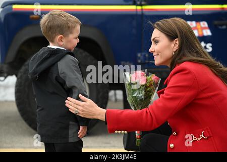 Die Prinzessin von Wales reagiert, als ihr während ihres Besuches in der RNLI Holyhead Lifeboat Station in Anglesey, Nordwales, von dem vierjährigen Theo Crompton eine schicke Blumenpracht überreicht wird, wo sie sich mit der Crew, Freiwilligen und einigen von ihnen traf, die von ihrer lokalen Einheit unterstützt wurden. Bilddatum: Dienstag, 27. September 2022. Stockfoto