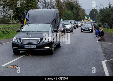 PERECHYN, UKRAINE - 25. SEPTEMBER 2022 - die Menschen knien, um dem Oberleutnant Armen Petrosian, 50, zu Respekt zu zeigen, der während der Befreiung der Northeas starb Stockfoto