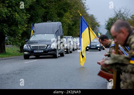 PERECHYN, UKRAINE - 25. SEPTEMBER 2022 - Soldaten knien, um dem Oberleutnant Armen Petrosian, 50, der während der Liberati starb, ihre letzte Ehre zu erweisen Stockfoto