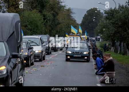 PERECHYN, UKRAINE - 25. SEPTEMBER 2022 - die Menschen knien, um dem Oberleutnant Armen Petrosian, 50, zu Respekt zu zeigen, der während der Befreiung der Northeas starb Stockfoto