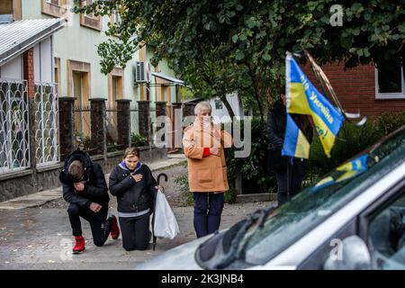 PERECHYN, UKRAINE - 25. SEPTEMBER 2022 - die Menschen knien, um dem Oberleutnant Armen Petrosian, 50, zu Respekt zu zeigen, der während der Befreiung der Northeas starb Stockfoto