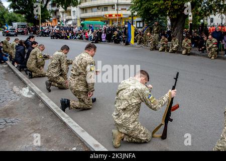 PERECHYN, UKRAINE - 25. SEPTEMBER 2022 - Soldaten knien, um dem Oberleutnant Armen Petrosian, 50, der während der Liberati starb, ihre letzte Ehre zu erweisen Stockfoto