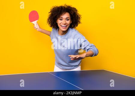 Portrait der positiven fröhlichen Person halten Tischtennis Schläger spielen Tennis isoliert auf gelbem Hintergrund Stockfoto