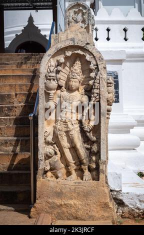 Wachstein am Eingang des Thuparama-Tempels, schlangengott und zwei Zwerge in einem Stein gemeißelt. Stockfoto