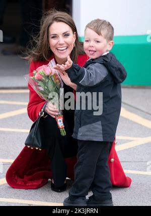 Die Prinzessin von Wales erhält von der vierjährigen Theo Crompton eine Menge Blumen, als sie zu einem Besuch der RNLI Holyhead Lifeboat Station in Holyhead, Wales, eintrifft, wo sie mit dem Prinz von Wales Crew trifft, Freiwillige und einige von denen, die von ihrer lokalen Einheit unterstützt wurden. Holyhead ist eine der drei ältesten Rettungsbootstationen an der walisischen Küste und hat eine bemerkenswerte Geschichte der Tapferkeit, da sie 70 Auszeichnungen für die Galanterie erhalten hat. Bilddatum: Dienstag, 27. September 2022. Stockfoto