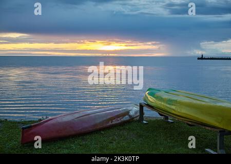 Kanuboote am Ufer des Bay Bay Bay Lake vor dem Hintergrund der untergehenden Sonne Stockfoto